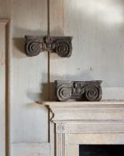 A PAIR OF CARVED WOOD AND POLYCHROME PAINTED CAPITALS IN THE IONIC ORDER