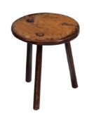 AN OAK TRIPOD LOW STOOL, PROBABLY A MILKING STOOL, 19TH CENTURY