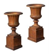 A PAIR OF GILT CAST IRON CAMPANA URNS ON PLINTHS, 20TH CENTURY
