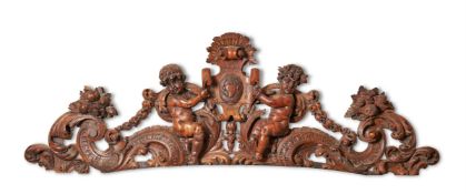 A CARVED LIMEWOOD CRESTING OF TWO PUTTI SUPPORTING A CARTOUCHE, LATE 17TH / EARLY 18TH CENTURY
