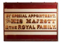 A REVERSE DECORATED GLASS ROYAL WARRANT SIGN