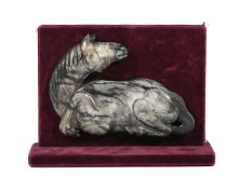 A Chinese black and white jade carving of a recumbent horse
