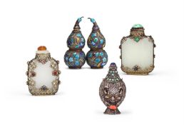 Y Two Chinese gilt-metal filigree mounted pale celadon or white jade snuff bottles and stoppers