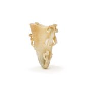 A large and finely carved Chinese pale celadon jade rhyton