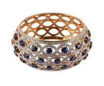 A SAPPHIRE AND DIAMOND HINGED BANGLE