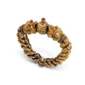 A gold coloured bangle formed from a series of articulated kirtimukha faces