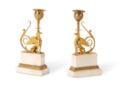 A PAIR OF GILT BRONZE AND WHITE MARBLE GRIFFIN CANDLESTICKS, EARLY 19TH CENTURY