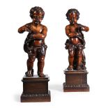 A PAIR OF CONTINENTAL CARVED WALNUT FIGURES OF PUTTI, PROBABLY EARLY 18TH CENTURY
