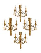 A SET OF FOUR CARVED GILTWOOD THREE BRANCH WALL LIGHTS, IN LOUIS XVI STYLE, 20TH CENTURY