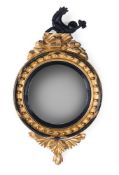 A REGENCY GILTWOOD AND EBONISED CONVEX WALL MIRROR, CIRCA 1815
