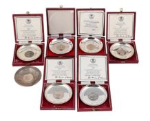A SET OF SILVER COMMEMORATIVE CIRCULAR DISHES