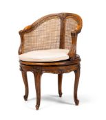 A CARVED WALNUT AND CANED DESK CHAIR, FRENCH, LATE 19TH OR EARLY 20TH CENTURY