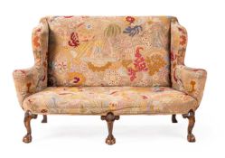 A WINGBACK NEEDLEPOINT UPHOLSTERED SETTE, GEORGE II STYLE, IN THE MANNER OF CHARLES TOZER