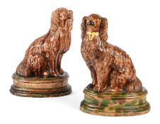 A PAIR OF BROWN AND GREEN GLAZED POTTERY MODELS OF SPANIELS, POSSIBLY SCOTTISH, LATE 19TH CENTURY