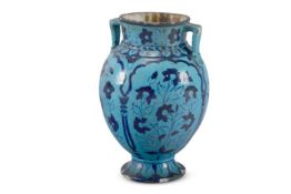 A TERRACOTTA BLUE GLAZED TWO HANDLED URN IN THE KASHAN STYLE, PROBABLY BOMBAY SCHOOL OF ART