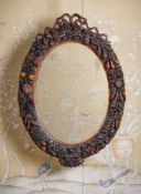 Y AN UNUSUAL CARVED EXOTIC HARDWOOD OVAL MIRROR, PROBABLY ANGLO INDIAN OR ANGLO-CHINESE, 19TH CENTUR