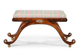 A BEECH AND GILT METAL MOUNTED X FRAMED STOOL OR WINDOW SEAT, IN REGENCY STYLE, 19TH CENTURY