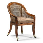 A REGENCY MAHOGANY AND CANED BERGERE ARMCHAIR IN THE MANNER OF GILLOWS, CIRCA 1820