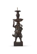 A Chinese signed bronze 'Foreigner' candlestick