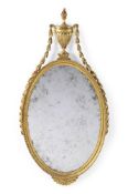 A GILTWOOD OVAL MIRROR, IN THE MANNER OF ROBERT ADAM, LATE 18TH OR EARLY 19TH CENTURY