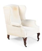 A WHITE CALICO UPHOLSTERED WING ARMCHAIR, IN THE STYLE OF HOWARD & SONS, EARLY 20TH CENTURY