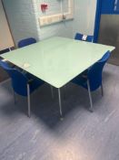 Glass topped square meeting room table with 4 blue cloth stacking chairs