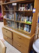 4 drawer wooden cabinet with glass fronted display and large quantity of books