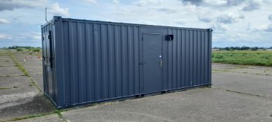 Converted 20ft (approx.) shipping container with large tinted windows to side, shuttered windows