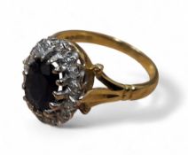 An 18ct gold, sapphire and diamond halo ring, set with a central oval sapphire approx. 18 x 15mm