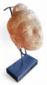 A Gandhara Stucco Buddha head, North Western Pakistan, with wavy hair, bun shaped usnisa, 14cm high,