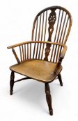 A 19th century yew, beech and elm wheelback Windsor elbow chair, saddle seat, turned legs, crinoline