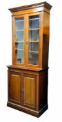 An early 20th century mahogany glazed bookcase, oversailing ogee cornice above glazed panelled