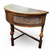 An early 20th century oak demi-lune hall table, deep bergère frieze, turned legs, 71cm high, 85cm