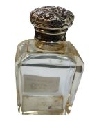 An Edwardian smelling salts bottle, of rectangular form, domed cover wmbossed with scrolling