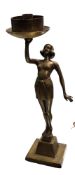 An Art Deco bronzed side light, of a lady, standing, topless,  holding aloft a dish, square base,