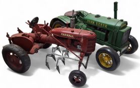 A large scale tinplate model of a 1950s McCormick-Deering Farmall A tractor with ploughing