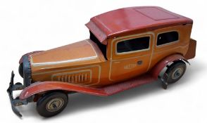 A Mettoy large scale tinplate clockwork car, orange body, orange/brown roof, running boards and