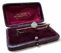 An unusual 9ct gold and opal bar brooch, centrally mounted with an orb made up of two opal cabochons