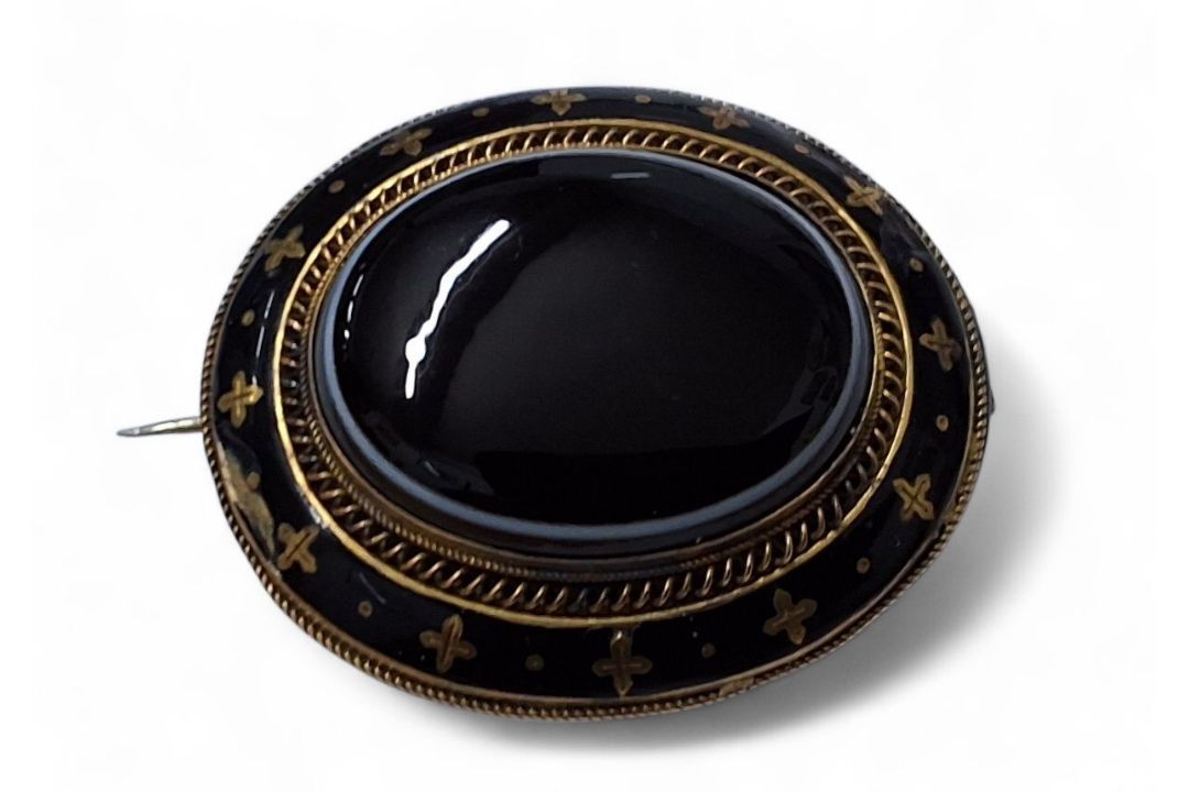 A Victorian gilt metal mourning brooch, oval banded onyx cabochon, banded black enamel border, - Image 1 of 2