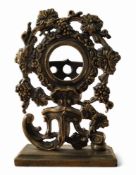 A 19th century brass pocket watch stand, cast throughout with fruiting vine and scrolls, rectangular