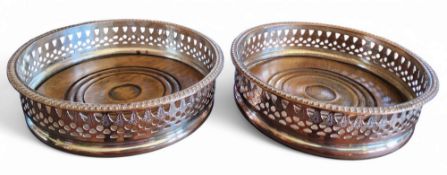 A pair of Sheffield Plated wine bottle coasters, draught turned bases, pierced sides, gadrooned