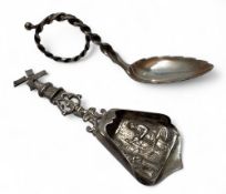 A Dutch silver coloured metal caddy spoon, the bowl embossed with figures, windmill terminal, 10cm