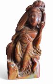 A Chinese soapstone figure, of Guanyin, with flowing robes by a crane, the verso with script, 20cm
