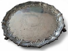 A Victorian shaped circular salver, the central well chased with foliate and scrolls, supported by