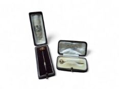 A 15ct gold and pearl pin, the head in the form of a knot centrally set with a pearl, the head