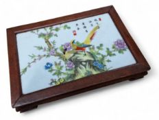 A Chinese porcelain famille rose tile set in a hardwood stand, 5cm high, 28cm wide, 19.5cm deep