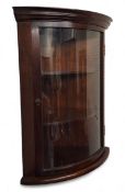 A mahogany bow fronted corner cabinet, glazed door, three shelves, signed 'M J More', 66 high,  36