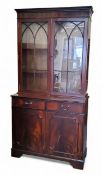 A reproduction mahogany bookcase cabinet, moulded dentil cornice above glazed doors, the