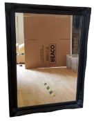 A large rectangular mirror, black frame with scrolls to angles, 74cm x 106cm