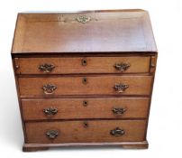 A George III oak bureau, the fall front enclosing fitted interior, bold brass escutcheon, four